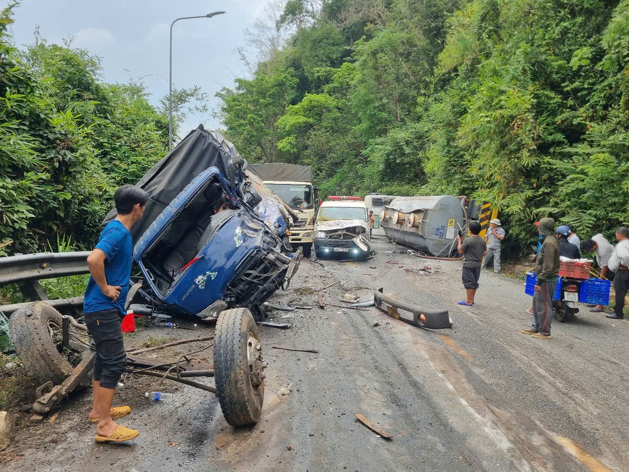 Xe ô tô tải bị hư hỏng nghiêm trọng, trong tình trạng biến dạng ca bin và cầu, 2 bánh trước rơi ra ngoài