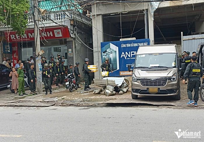 Lực lượng chức năng mang các thùng tài liệu được niêm phong ra ngoài. Ảnh: Trần Nghị