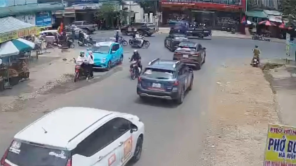 Ngoài chiếc ô tô chắn làn đường còn có thêm 1 người từ xe bán tải bước sang "điều tiết" để đoàn xe doanh nhân qua đường. Ảnh: Cắt từ clip Cơ quan CSĐT vào cuộc vụ ô tô chắn ngang quốc lộ 20 cản đường cho đoàn xe doanh nhân qua đường