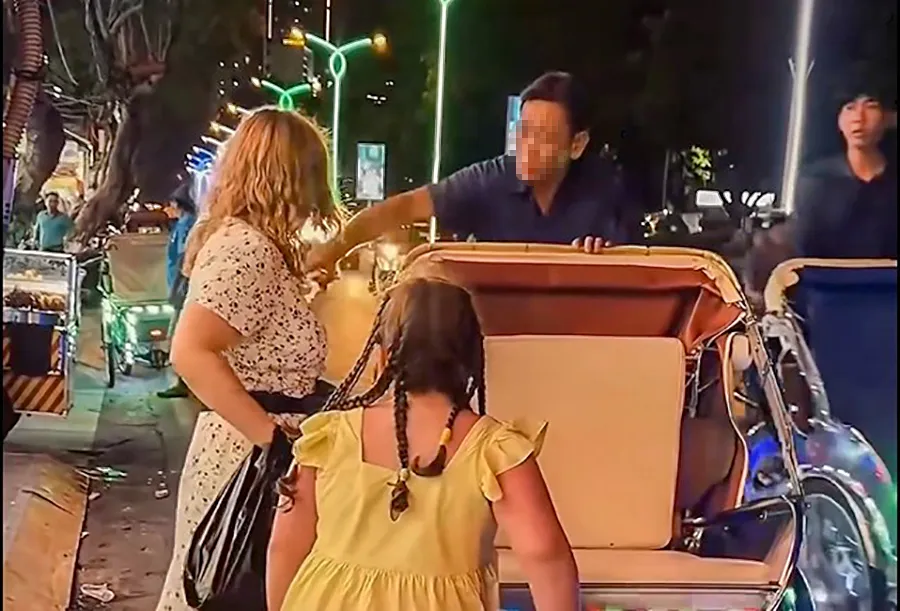 Người lái xích lô giật xấp tiền khiến hai du khách sợ hãi. Ảnh: AB