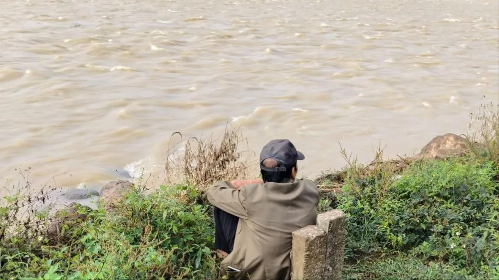 Người cha còm cõi ngồi trên bờ ngóng tin con. Ảnh: A.D con gái (2).jpg